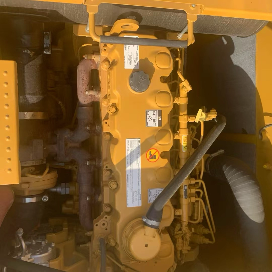 Caterpillar heavy machinery engine compartment showing valve cover, exhaust manifold, and CAT DEO label. Caterpillar heavy machinery engine compartment showing valve cover, exhaust manifold, and CAT DEO label.