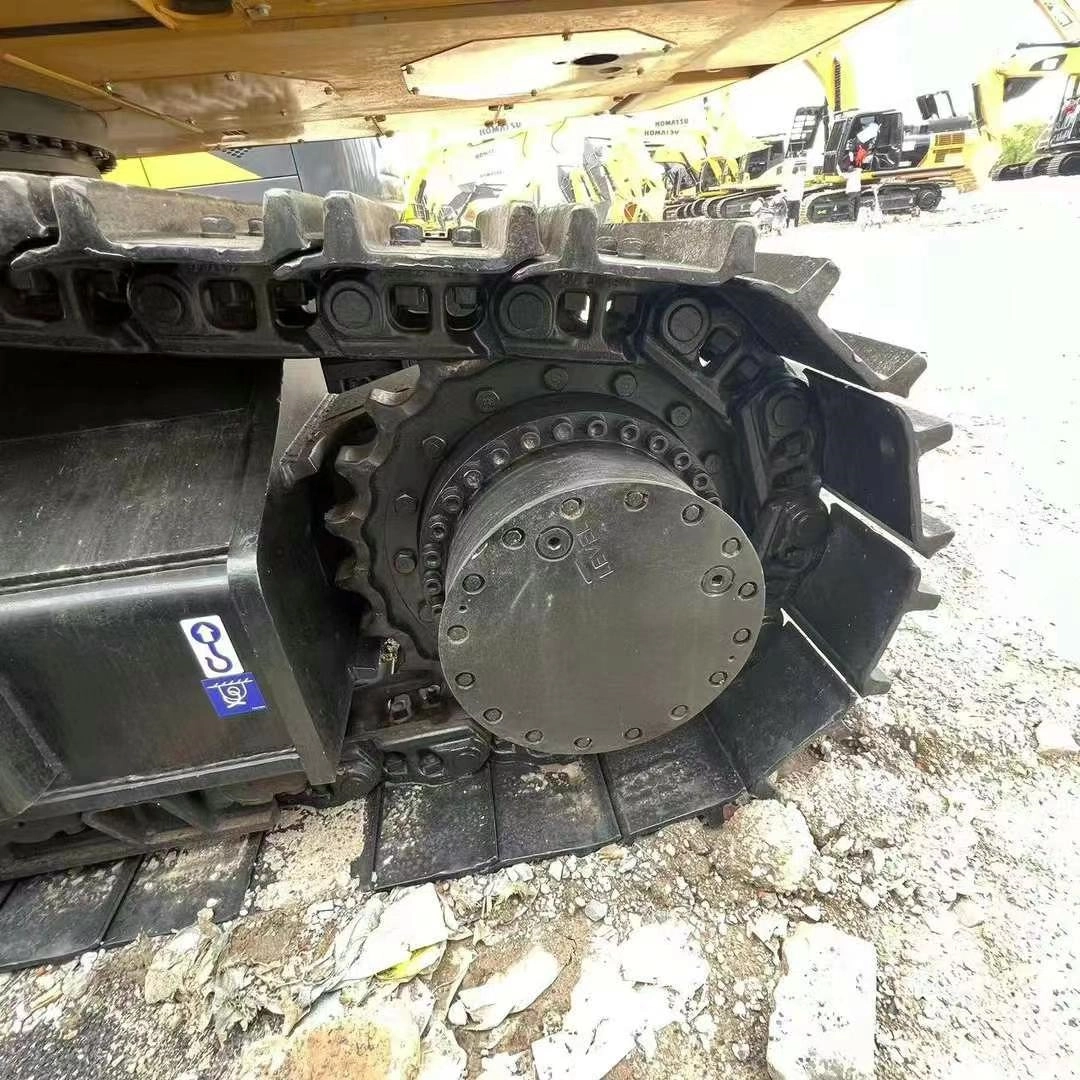 Komatsu excavator final drive motor and steel tracks in good condition at construction yard.