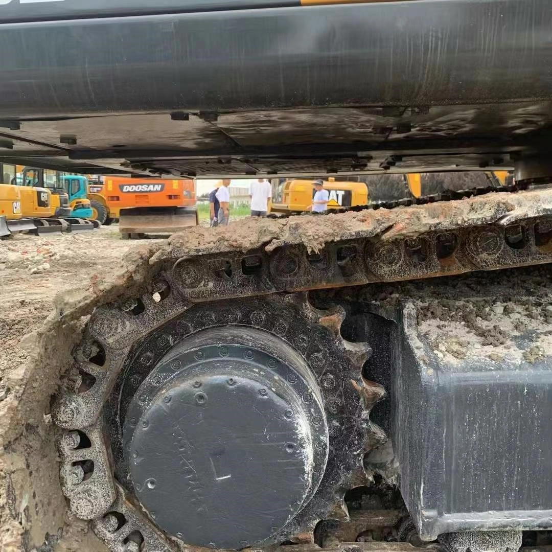 Komatsu excavator undercarriage final drive, sprocket, and muddy tracks close-up showing operational wear.