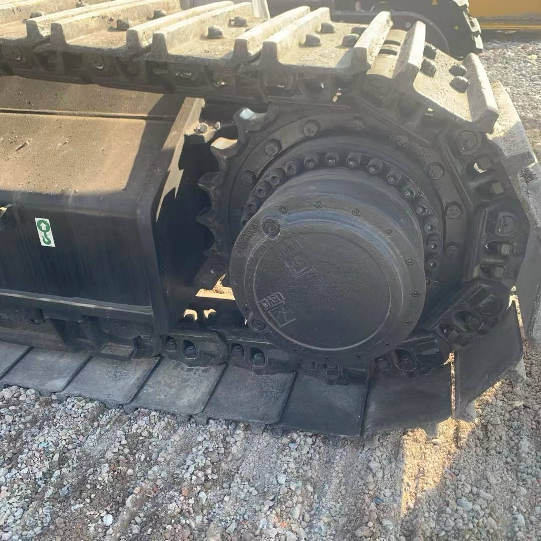 Unknown brand excavator final drive and steel tracks showing light wear on gravel Unknown brand excavator final drive and steel tracks showing light wear on gravel